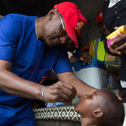 Dr. Tunji Funsho administers polio vaccine to a child in Makoko, a neighborhood in Lagos, while Tiwa Savage looks on. Tiwa Savage, Nigerian pop star and mother, joined Dr. Tunji Funsho, Chair of Rotary's National PolioPlus Committee for Nigeria, to participate in a National Immunization Day in Lagos, Nigeria on 22 April 2017. Savage recently joined the End Polio Now campaign as a Polio Ambassador.
